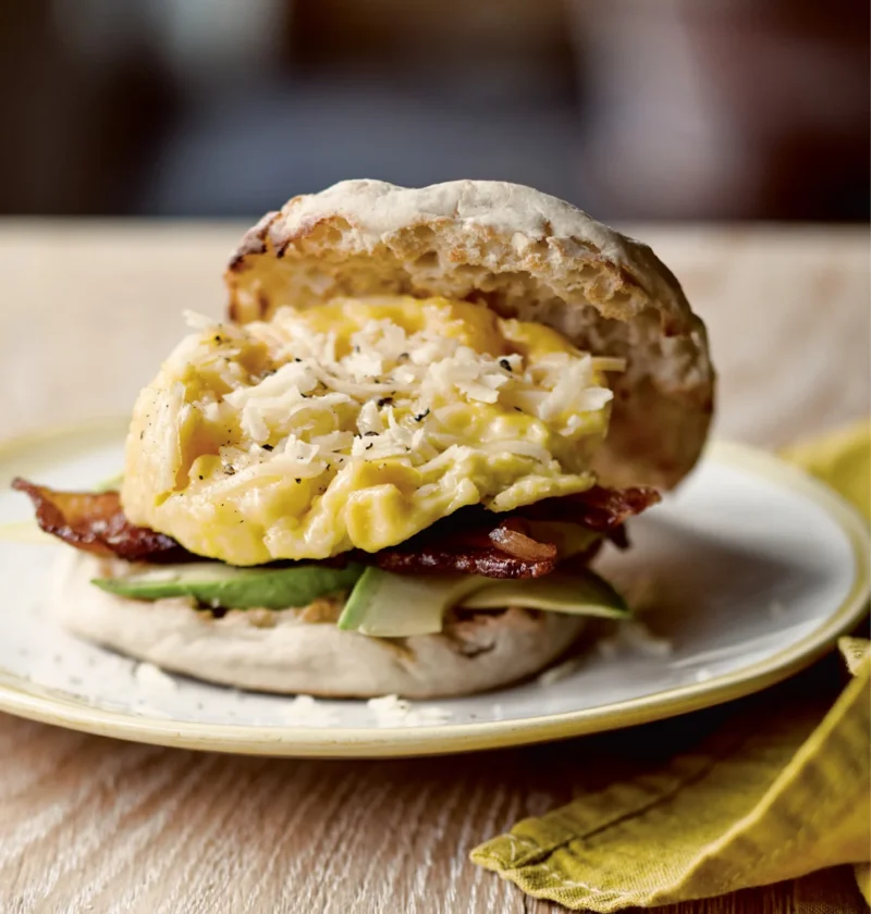 Ina Garten bacon, egg and cheddar sandwich on a toasted English muffin with avocado and applewood-smoked bacon
