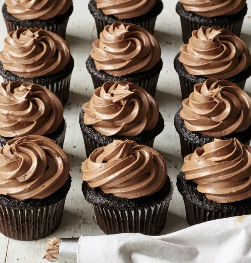 Ina Garten Beatty's chocolate cupcakes topped with chocolate buttercream frosting on a white plate