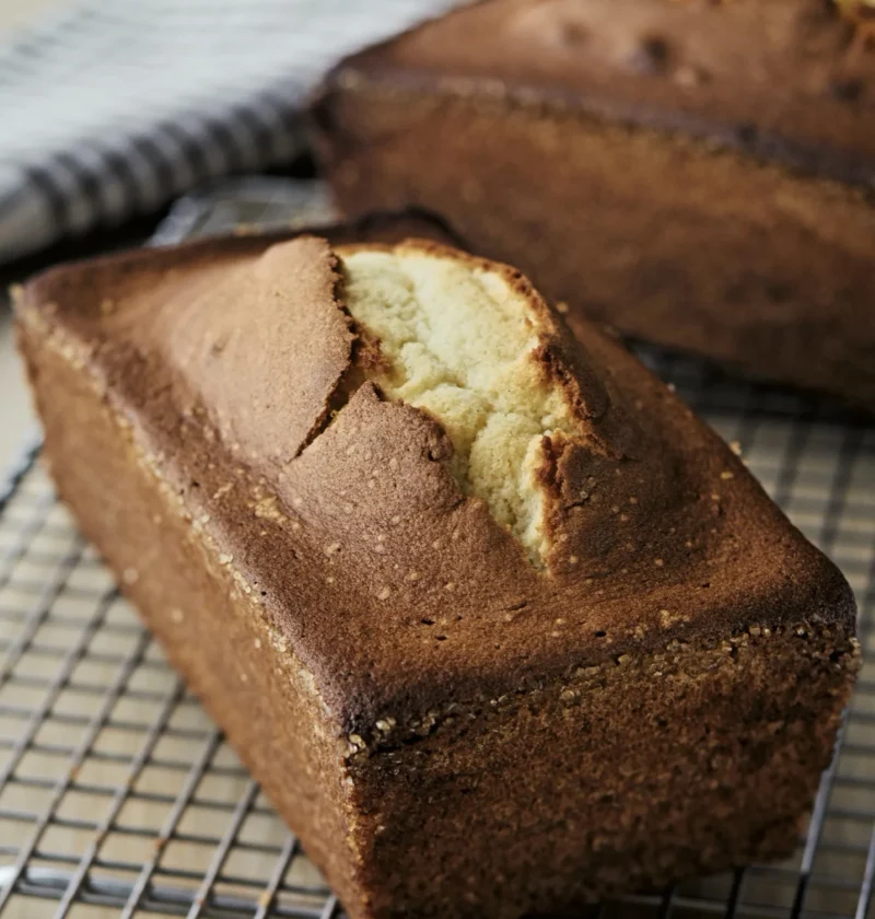 Two golden loaves of Ina Garten vanilla pound cake with a crackly turbinado sugar crust, sliced to show the dense tender crumb inside