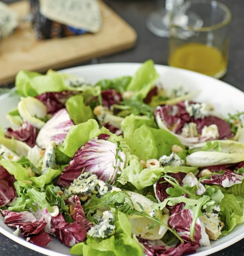 A bowl of winter greens with crumbled Stilton cheese and toasted hazelnuts, Ina Garten winter greens with Stilton and hazelnuts recipe