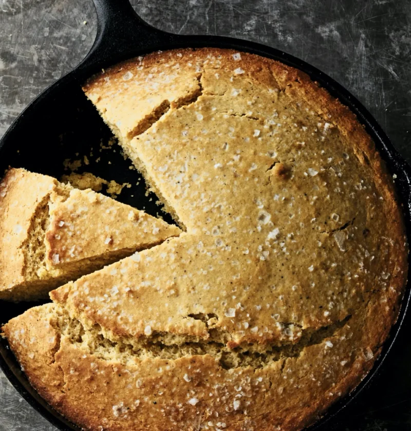 Ina Garten brown butter skillet cornbread in a cast-iron pan, golden on top with flaked sea salt