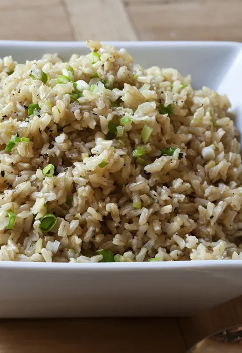 A bowl of gingered basmati rice with visible scallions and herbs, a flavorful ina garten side dish