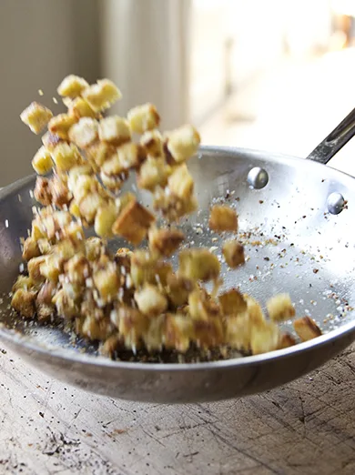 Golden homemade croutons pan-fried in olive oil, served in a bowl ready to top salads and soups