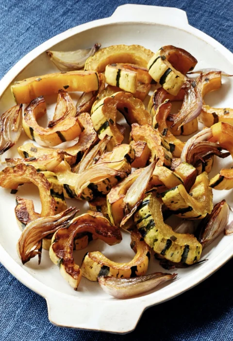Honey-roasted delicata squash slices with caramelized shallots and fresh sage on a sheet pan, a simple Ina Garten side dish
