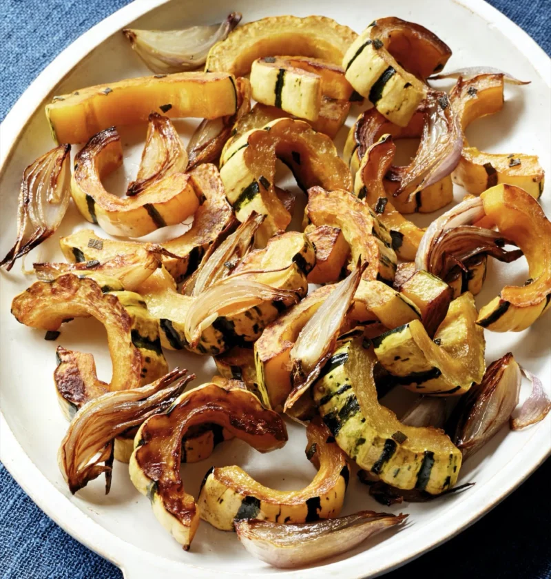 Honey-roasted delicata squash slices with caramelized shallots and fresh sage on a sheet pan, a simple Ina Garten side dish