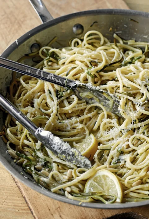 A plate of lemon linguine with zucchini ribbons, toasted pine nuts, fresh basil, and Parmesan cheese