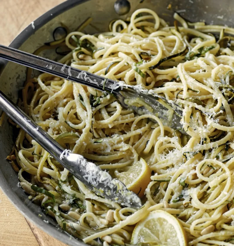 A plate of lemon linguine with zucchini ribbons, toasted pine nuts, fresh basil, and Parmesan cheese