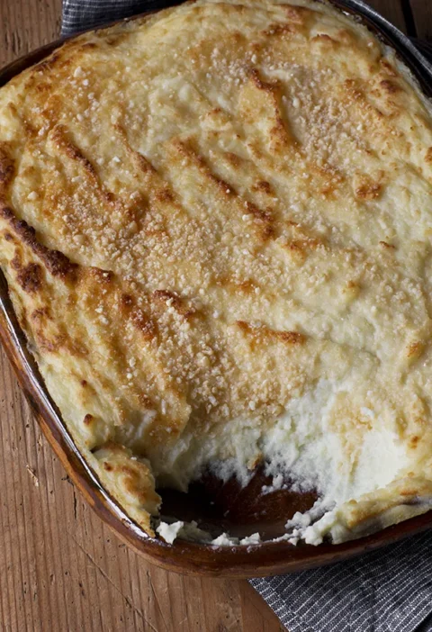 Creamy ina garten make-ahead goat cheese mashed potatoes with golden Parmesan crust in an oval baking dish