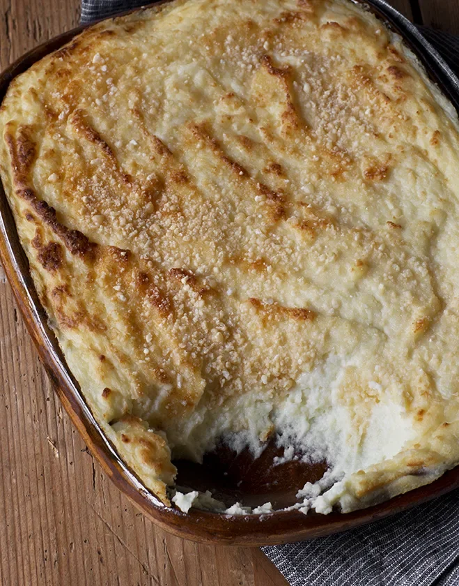 Creamy ina garten make-ahead goat cheese mashed potatoes with golden Parmesan crust in an oval baking dish