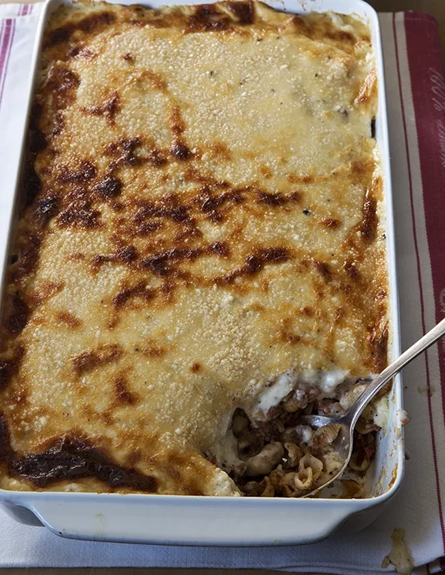 Ina Garten pastitsio in a baking dish with golden bubbly Parmesan béchamel topping