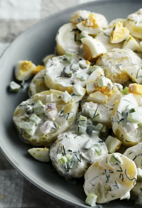 A bowl of creamy ina garten potato salad à la julia child with Yukon Gold potatoes, fresh dill, cornichons, and hard-boiled eggs