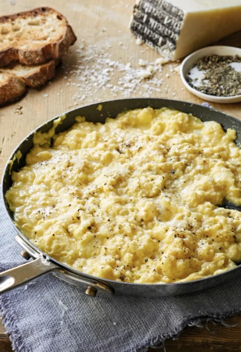 Soft custardy scrambled eggs cacio e pepe topped with grated Pecorino cheese on toasted country bread