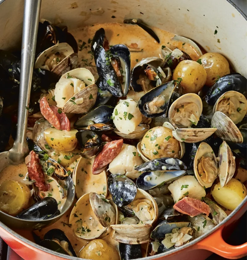 A bowl of shellfish and chorizo stew with scallops, clams, and mussels in a creamy white wine broth, Ina Garten shellfish and chorizo stew recipe