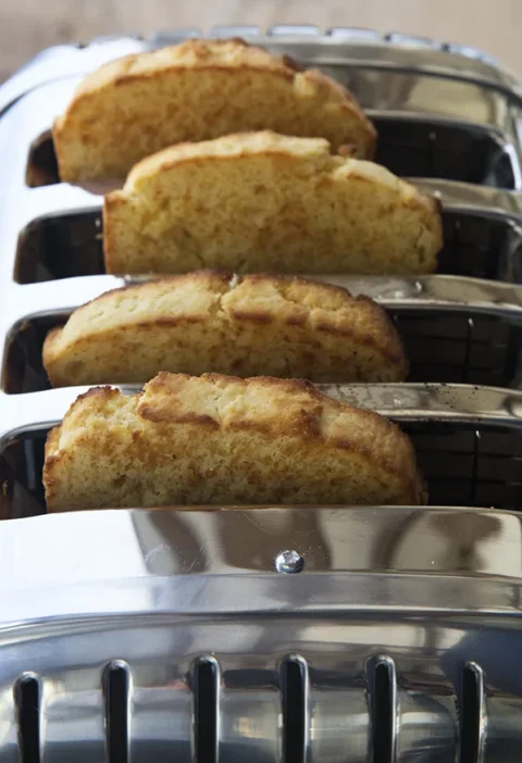 Two loaves of Ina Garten sour cream corn bread sliced and golden on a cutting board