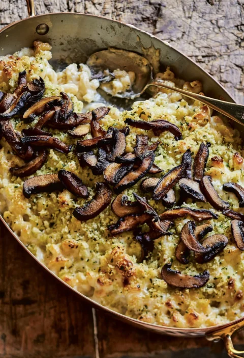 Truffled mac and cheese with sautéed mushrooms and herbed bread crumbs in a baking dish, showing the golden top and creamy pasta underneath