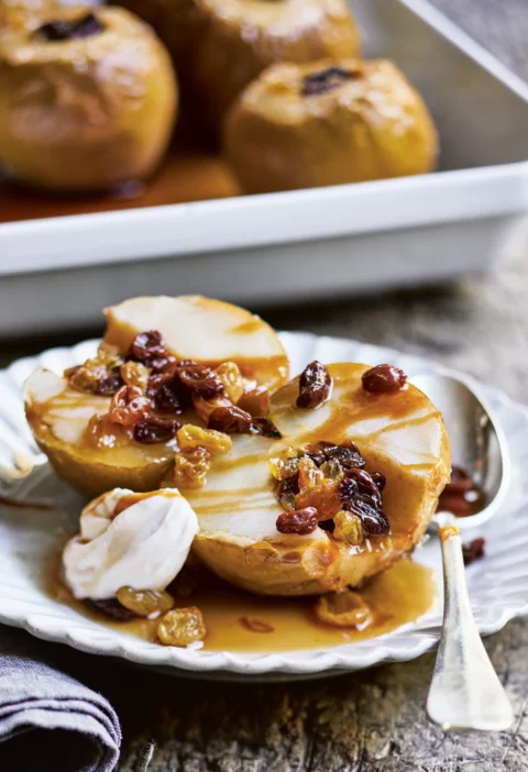 Ina Garten tuscan baked apples halved in a baking dish with caramelized pan juices and mascarpone cream