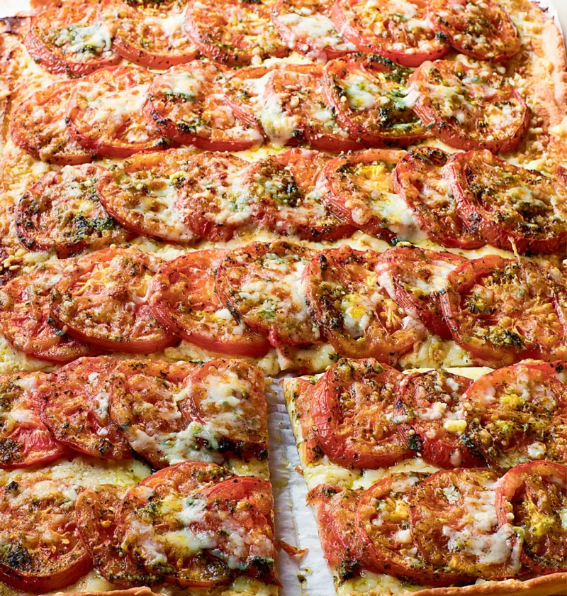 Ina Garten Anna's tomato tart with rows of overlapping sliced tomatoes, melted Gruyère and herbs on a golden crust