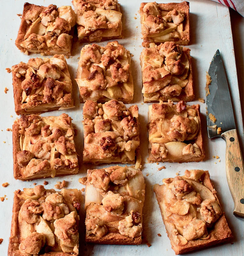 Ina Garten apple pie bars cut into squares with a golden walnut crumble topping and tender apple slices on a cutting board