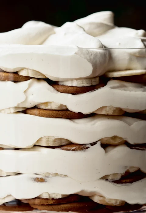Ina Garten banana rum trifle layered with ginger snaps, banana slices and rum cream in a straight-sided glass bowl