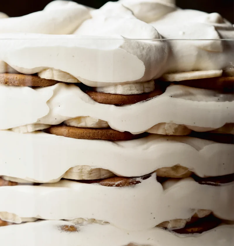 Ina Garten banana rum trifle layered with ginger snaps, banana slices and rum cream in a straight-sided glass bowl