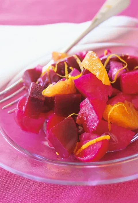 Ina Garten beets with orange vinaigrette, diced beets with orange segments and zest on a glass plate