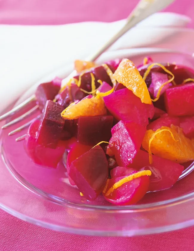 Ina Garten beets with orange vinaigrette, diced beets with orange segments and zest on a glass plate