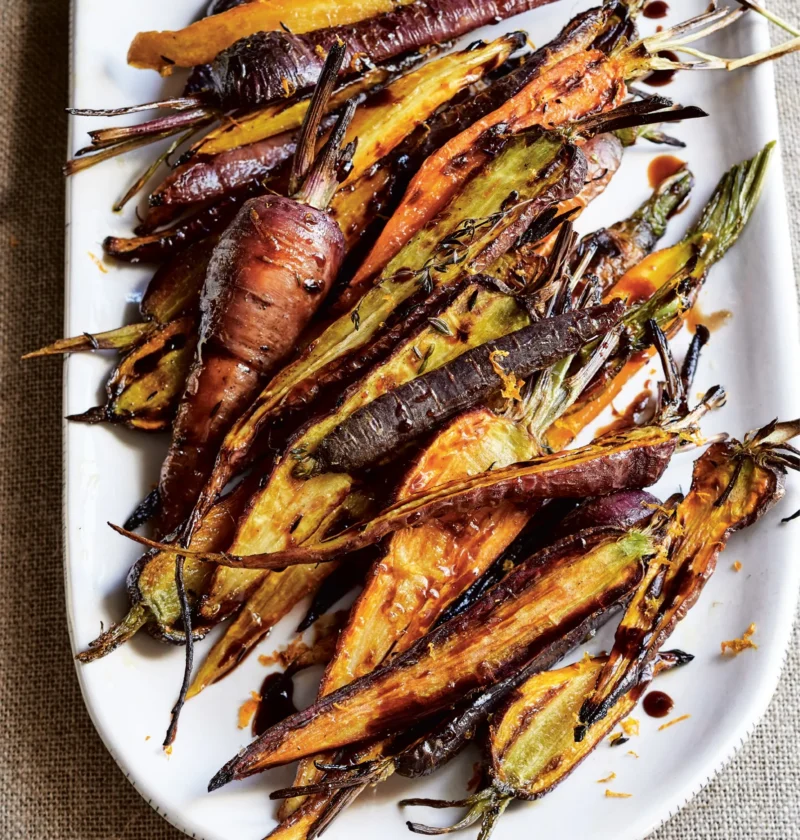 Ina Garten charred carrots, rainbow carrots broiled with thyme and drizzled with balsamic on a white oval platter
