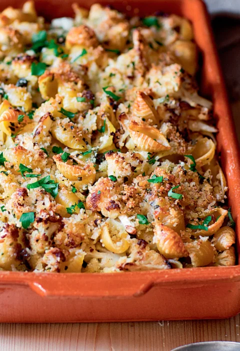 Ina Garten crusty baked shells and cauliflower in a terracotta baking dish topped with golden panko and fresh parsley