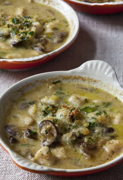 Ina Garten easy coquilles Saint Jacques in a white gratin dish with scallops, mushrooms and parsley in a creamy sauce