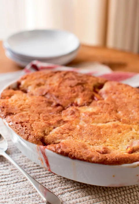Ina Garten fresh peach cobbler with golden drop biscuit topping baked in a white oval dish