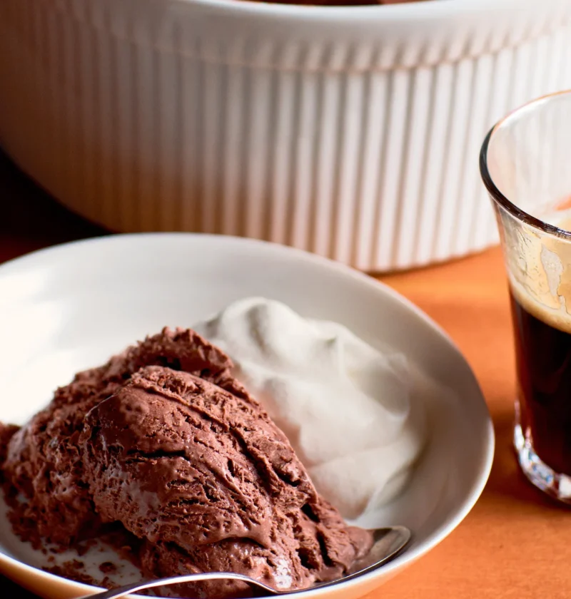 Ina Garten frozen mocha mousse scoop served in a white bowl with whipped cream next to a glass of espresso