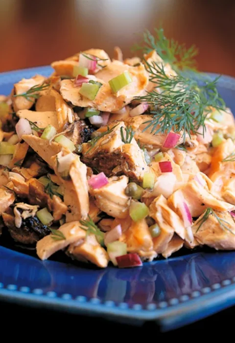 Ina Garten grilled salmon salad with large salmon flakes, diced celery, red onion and fresh dill on a blue plate