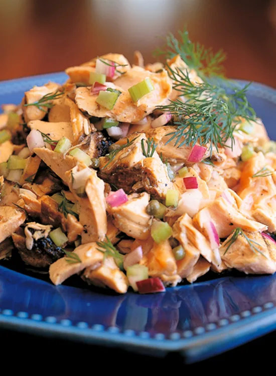 Ina Garten grilled salmon salad with large salmon flakes, diced celery, red onion and fresh dill on a blue plate