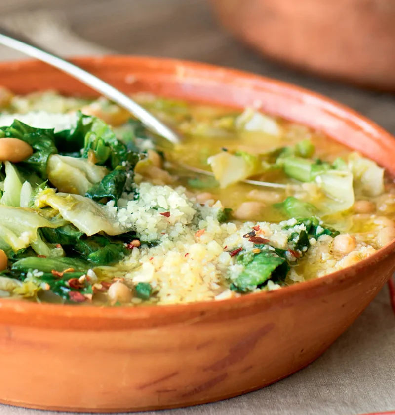 Ina Garten Italian white beans and escarole in a terracotta bowl with grated cheese and red pepper flakes