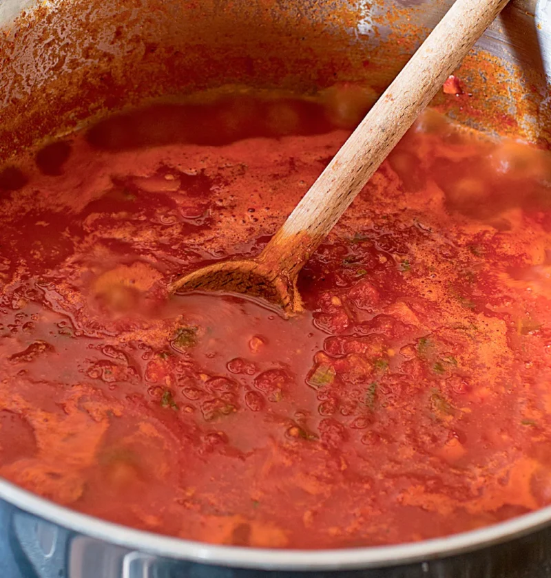 Ina Garten orecchiette with farm stand pasta sauce simmering in a pot with a wooden spoon