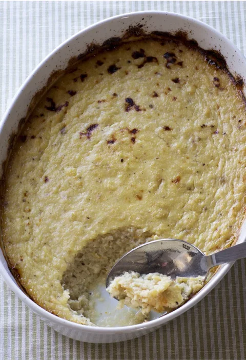 Ina Garten pear and parsnip gratin in an oval white baking dish with a spoonful scooped out