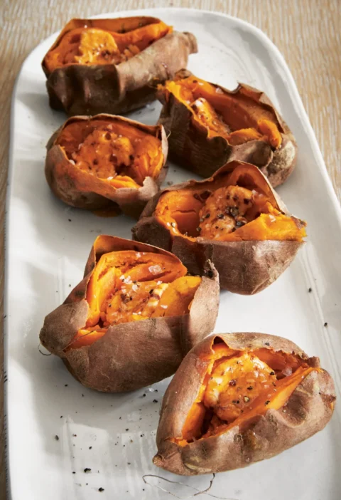 Ina Garten roasted sweet potatoes with chipotle orange butter split open on a white serving platter