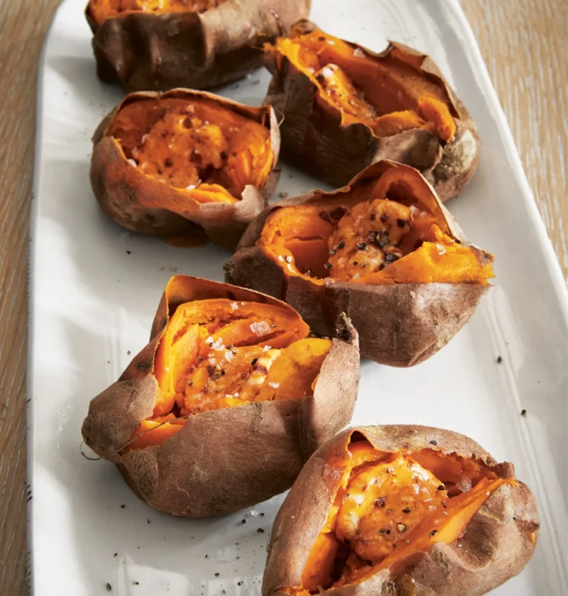 Ina Garten roasted sweet potatoes with chipotle orange butter split open on a white serving platter