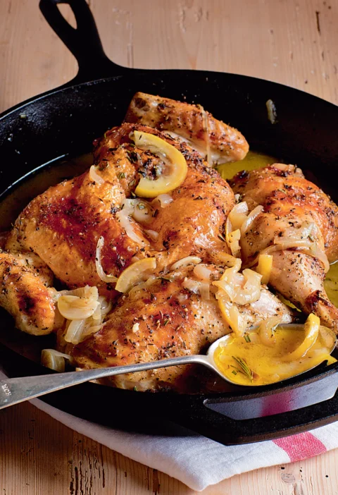 Ina Garten skillet-roasted lemon chicken with caramelized lemon slices and onion in a cast-iron skillet