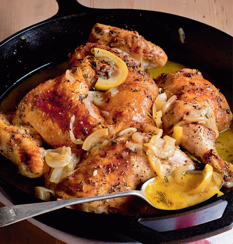 Ina Garten skillet-roasted lemon chicken with caramelized lemon slices and onion in a cast-iron skillet