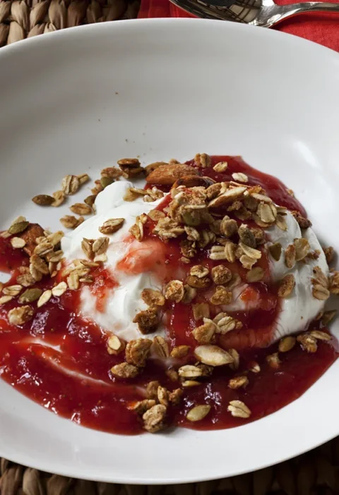 Ina Garten strawberry rhubarb compote with Greek yogurt and granola in a white bowl
