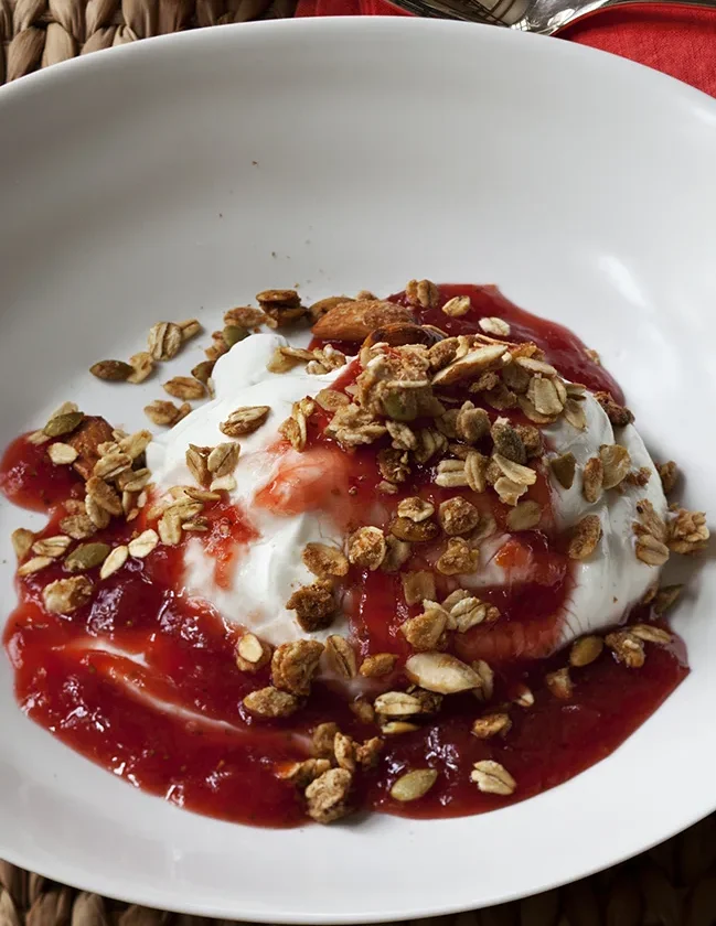 Ina Garten strawberry rhubarb compote with Greek yogurt and granola in a white bowl
