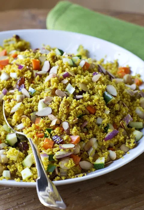 Ina Garten summer vegetable couscous with diced zucchini, carrots, red onion and toasted almonds in a white bowl
